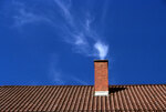 Rauchender Kamin auf einem Dach (Foto: kexchen - Fotolia)
